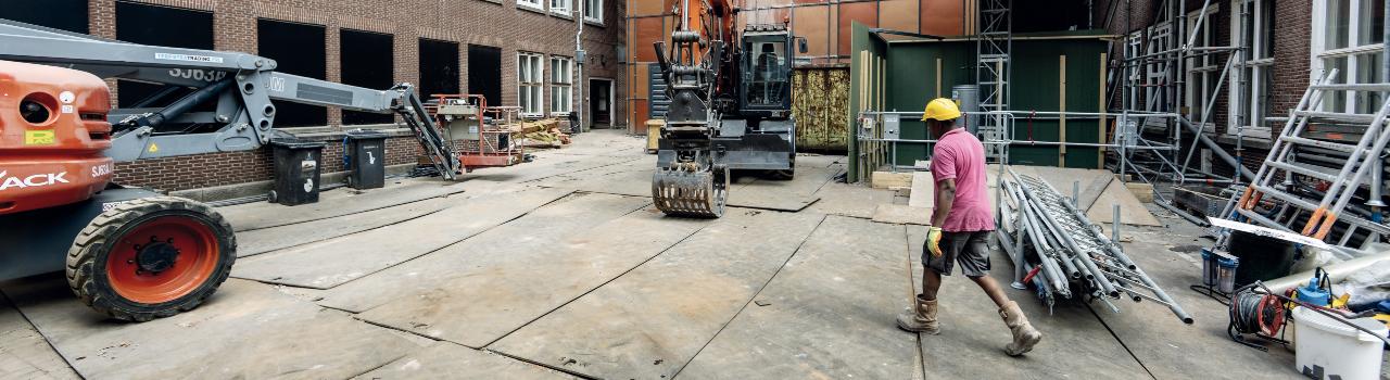  Man loopt over bouwplaats