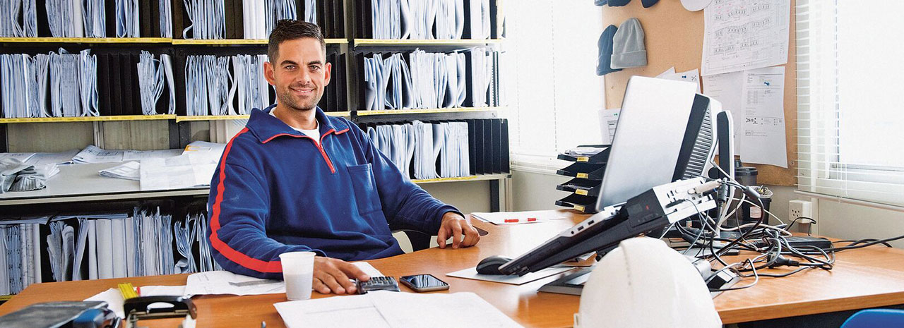  Man achter bureau aan het werk op laptop