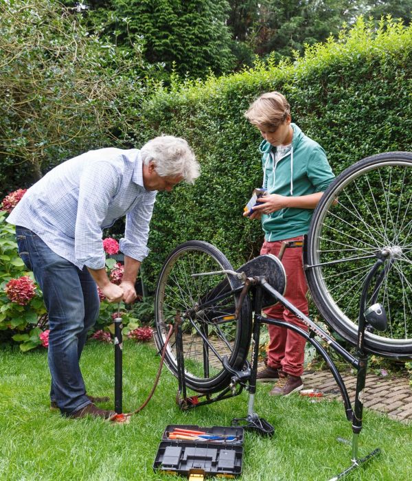 Man repareert fiets met kleinzoon